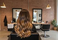Lived-in balayage melting from a dark root into warm honey ends