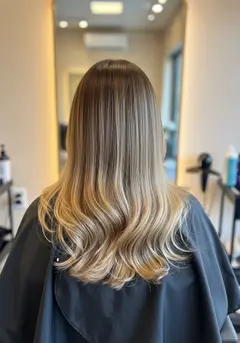 Long balayaged hair straight after its finishing gloss, with very high shine