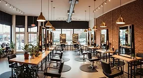 The salon interior: a brick wall, pendant lights and rows of styling stations