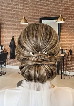 A polished bridal low chignon with pearl pins set into the twist