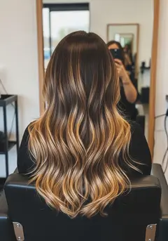 Hand-painted honey balayage melting from a dark root into warm gold ends